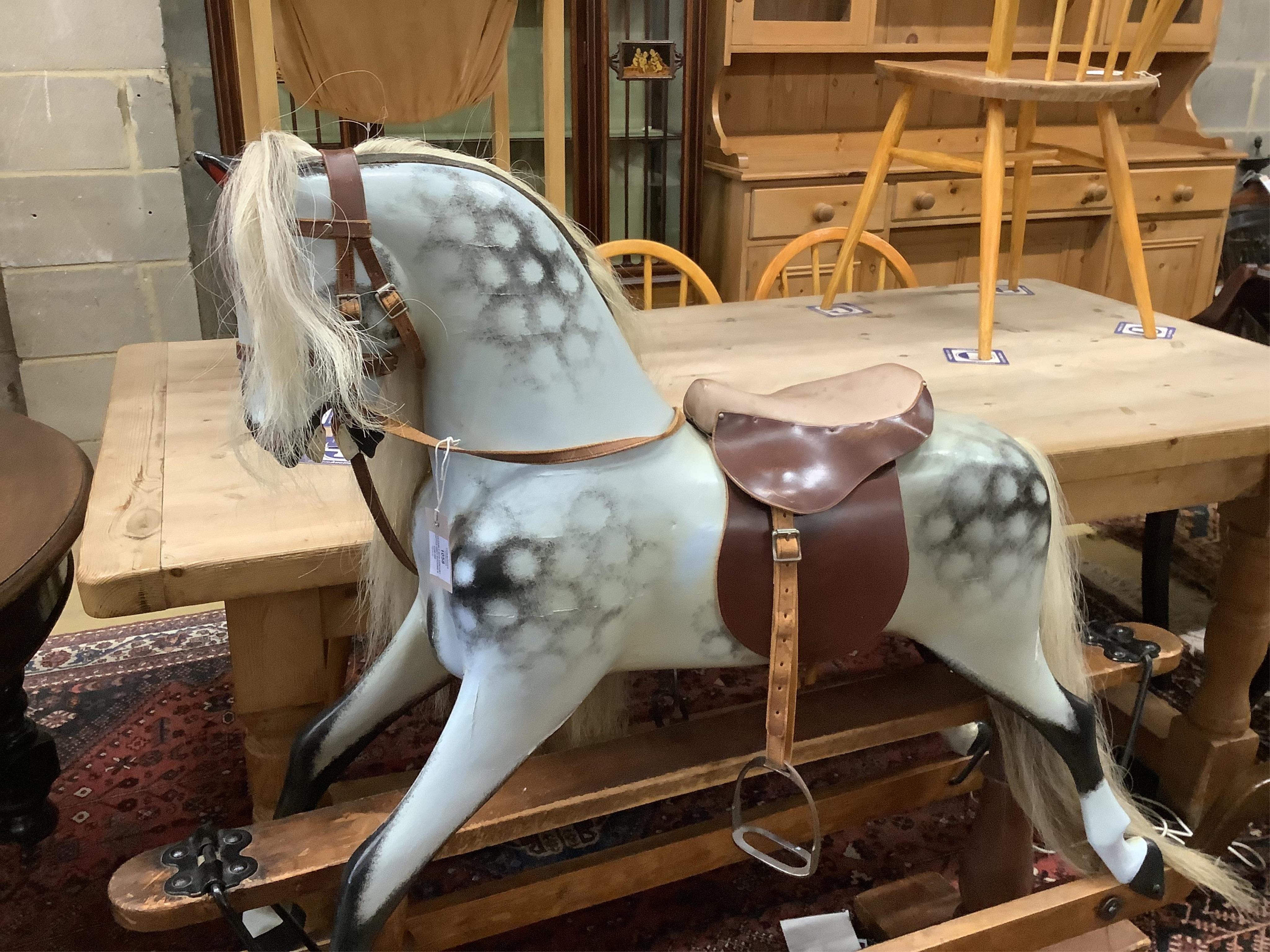 An early 20th century dapple grey rocking horse on pine safety frame, width 126cm, height 116cm. Condition - fair-good